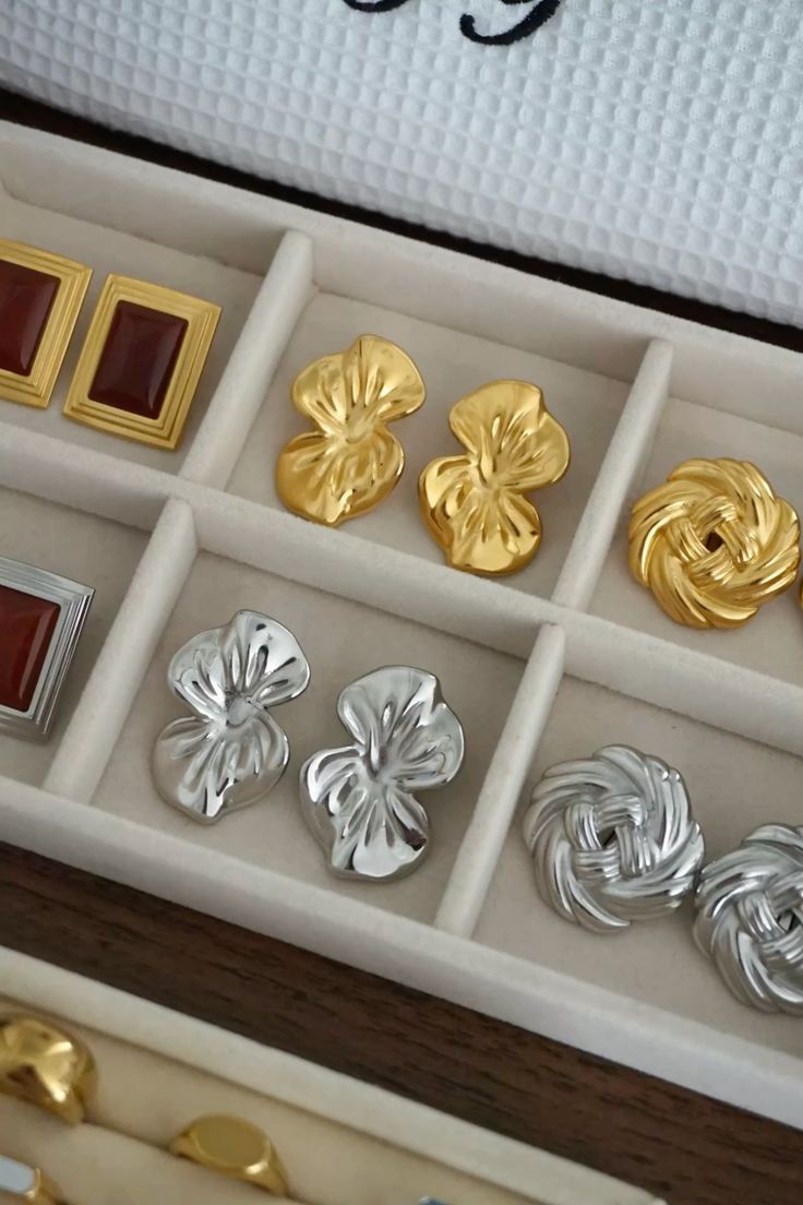 Gold and silver floral statement earrings in a jewelry box