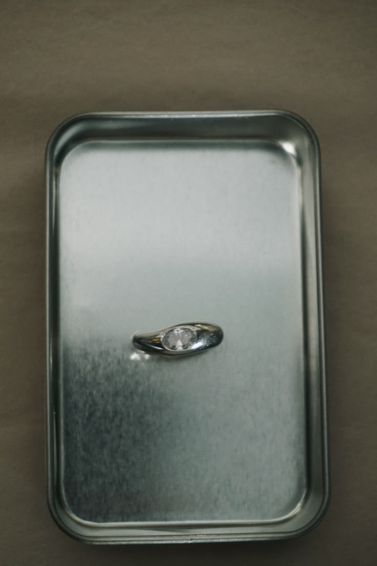 silver ring on a silver metallic tray