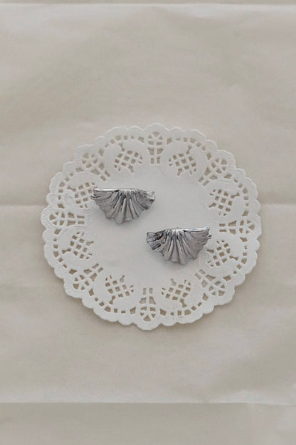 Silver shell earrings on a lace doily