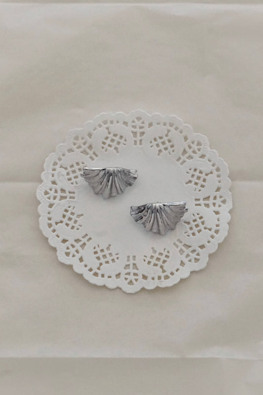Silver shell earrings on a lace doily