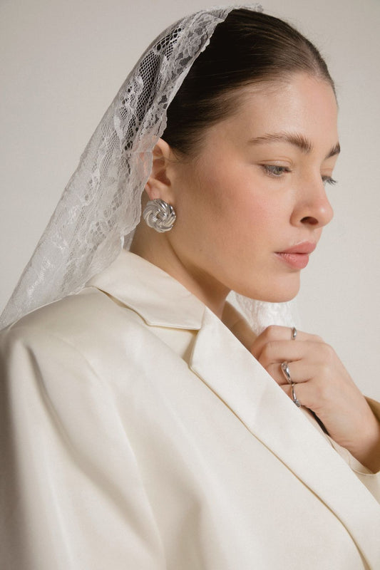 Women wearing Third Tone's silver Knot Earrings, styled with lace headscarf and beige blazer