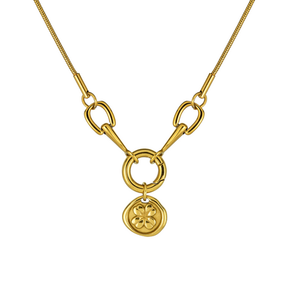 A gold-plated necklace with a delicate four-leaf clover pendant and a horseshoe link, designed on a white background.