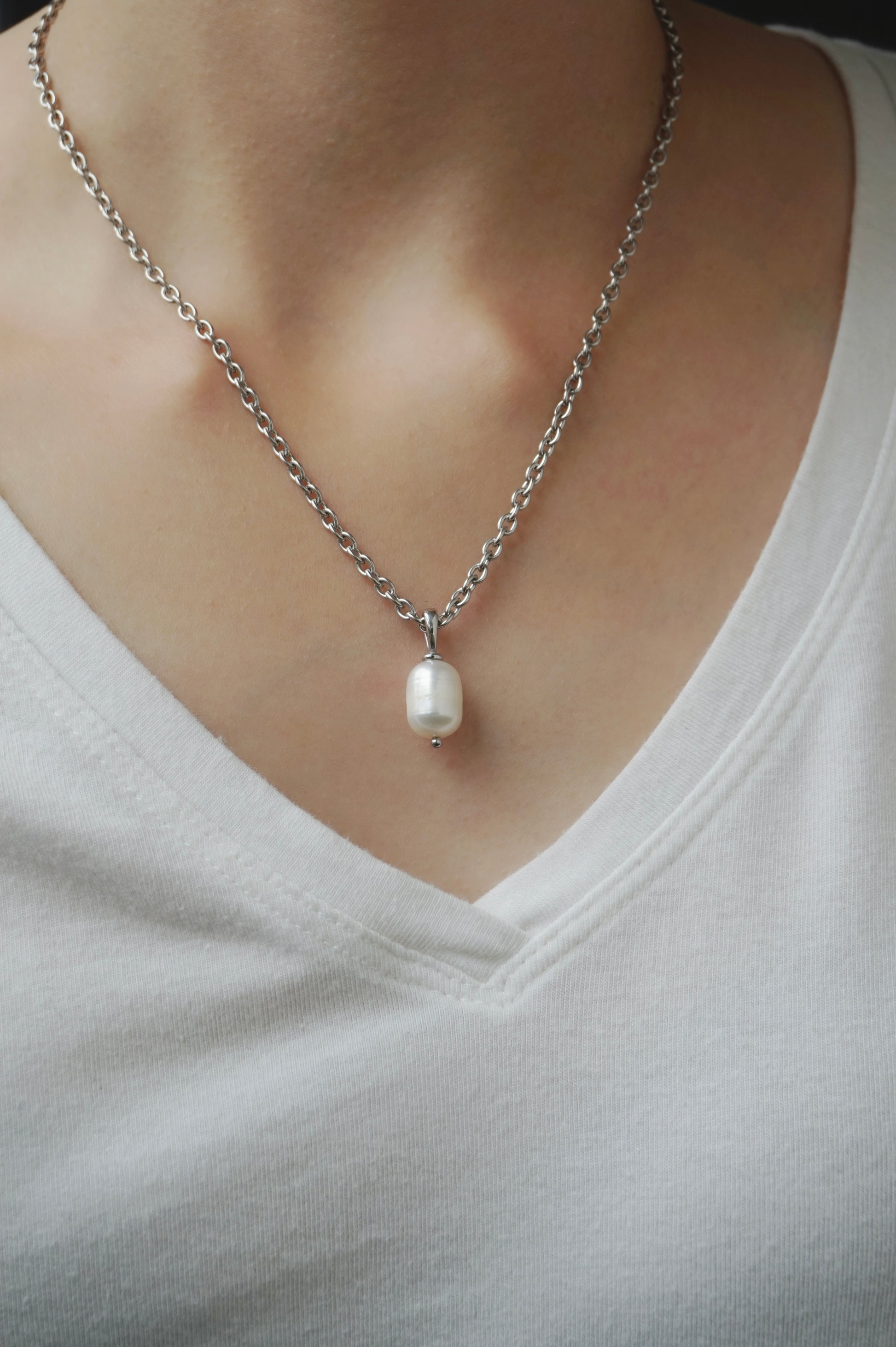 Pearl necklace on a person wearing a light-colored shirt