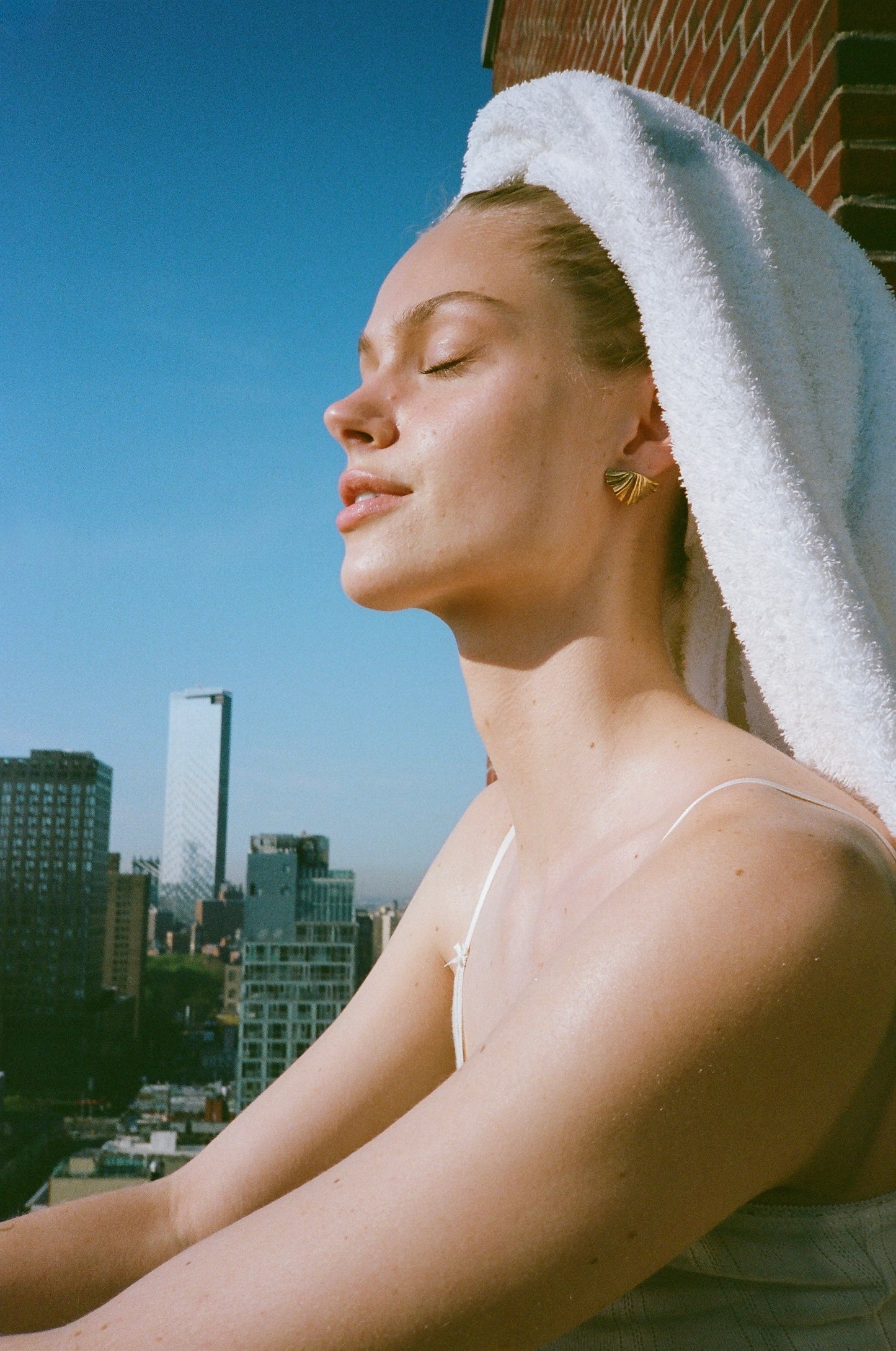 a model showcasing shell earrings with a nyc background